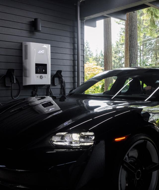 Charging black electric car at home inside the garage